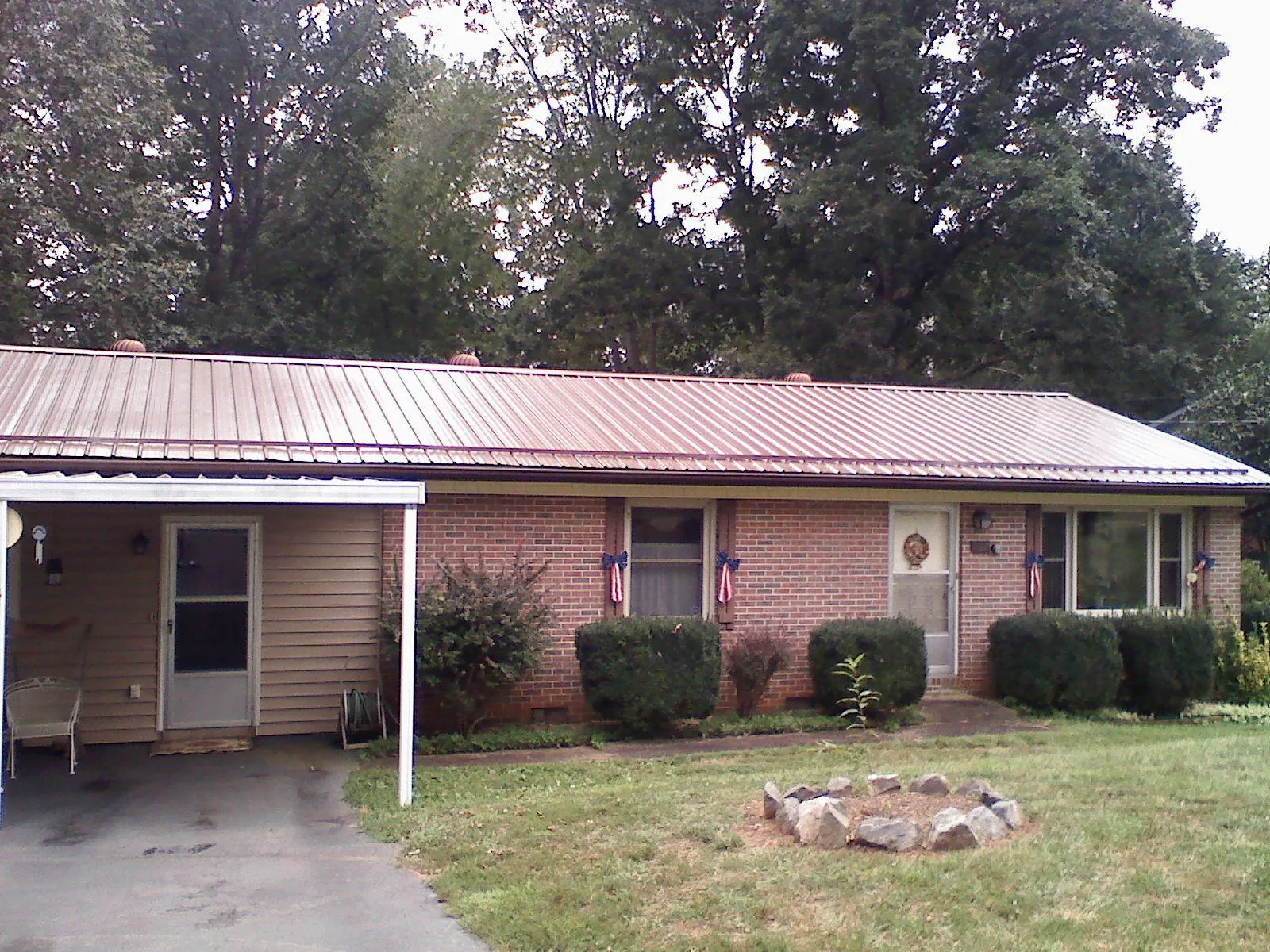Bronze metal roof and carport on a brick ranch home — Roof Repair work by our crew in Massapequa Park
